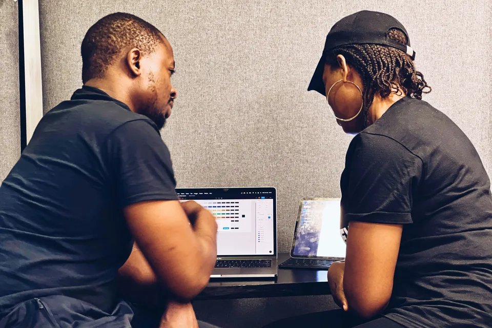 Two colleagues reviewing work together on a laptop.